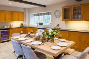a large kitchen with a wooden table and chairs at Calcot Farmhouse in Chirbury