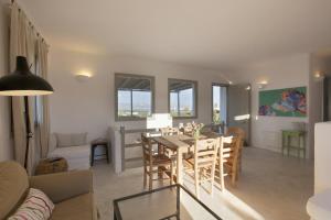 Un comedor y una sala de estar con mesa y sillas. en Kallisti Rodia - Dream Villa with Views Garden nr Best kid's Beach, en Santa Maria
