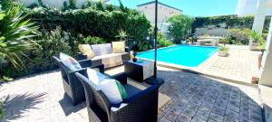 a patio with chairs and a swimming pool at The Sandcastle Guesthouse - Melkbosstrand in Melkbosstrand