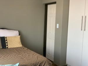 a bedroom with a bed and a door at Orlando Manor in Soweto