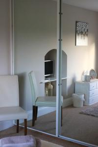 a room with a chair and a television and a mirror at Cheviot View - Newton by the Sea, Northumberland in Alnwick