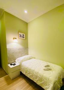 a bedroom with a white bed and a green wall at Garibaldi Home in Frosinone