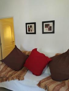 a bed with two red pillows on top of it at Cabañas Montoya in Paraná