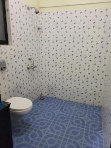 łazienka z toaletą i niebieską podłogą w obiekcie Sunshine Park Homes w mieście Colva