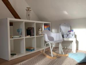 a white chair and a shelf in a room at gemütliches Einfamilienhaus in Gera mit 3 Schlafzimmern mit Garten und Parkplatz in Gera