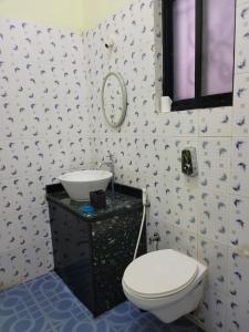 a bathroom with a toilet and a sink at Sunshine Park Homes in Colva
