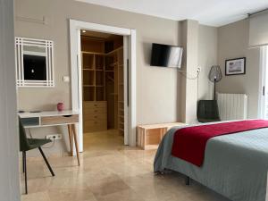 a bedroom with a bed and a desk and a chair at San Miguel B&B Granada in Granada