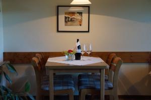 einen Tisch mit einer Flasche Wein und Gläsern in der Unterkunft Gästehaus Brunner in Zwiesel
