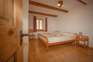 una camera con letto e pavimento in legno di Hotel und Restaurant Alpina a Savognin