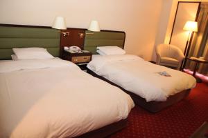 ein Hotelzimmer mit zwei Betten und einem Spiegel in der Unterkunft ANA Crowne Plaza Hotel Kyoto by IHG in Kyoto