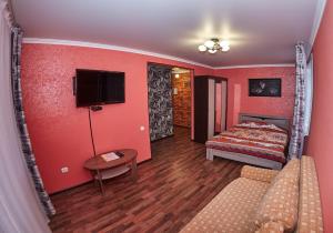 1 dormitorio con paredes rojas, 1 cama y 1 sofá en Триумф, en Petropavlovsk