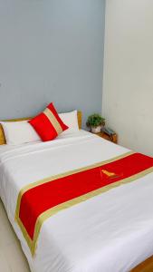 Una gran cama blanca con una manta roja y amarilla. en Hotel Bảo Quang, en Phú Khê (2)