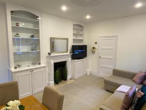 a living room with a fireplace and a tv at Lovely 3 bedroom maisonette with private roof terrace in Hammersmith in London