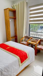 a bedroom with a bed and a table and a window at Hotel Bảo Quang in Phú Khê (2)