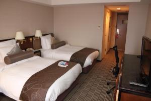 a hotel room with two beds and a television at ANA Crowne Plaza Hotel Kyoto by IHG in Kyoto