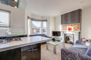 a kitchen and living room with a couch and a table at Lovely place, perfect for family and business travellers ideally located between the commons in London