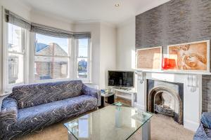 a living room with a couch and a fireplace at Lovely place, perfect for family and business travellers ideally located between the commons in London