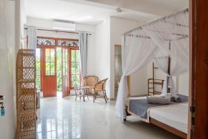 a bedroom with a bed with a canopy at Rise - Bed & Breakfast in Weligama