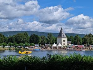 ein kleines gelbes Boot im Wasser neben einer Kirche in der Unterkunft Kenner Treff in Kenn