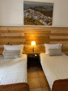 a room with two beds and a lamp on a table at The Tiles House in Faro