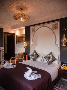 Una habitación de hotel con una cama con toallas. en Riad Zagouda en Marrakech