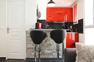 a kitchen with red cabinets and two black bar stools at Marché aux Puces de Saint-Ouen in Saint-Ouen +10 photos