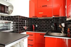 a kitchen with red cabinets and a sink at Marché aux Puces de Saint-Ouen in Saint-Ouen
