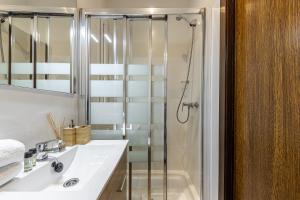 a bathroom with a shower and a sink and a mirror at BNBHolder Bright Plaza España in Madrid