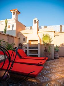eine Terrasse mit roten Stühlen und ein Haus in der Unterkunft Riad Zagouda in Marrakesch