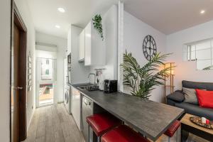 a kitchen and living room with a counter and a couch at BNBHolder Bright Plaza España in Madrid