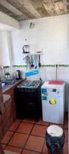 a kitchen with a stove and a small refrigerator at Ancora in Punta Del Diablo