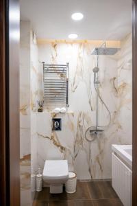 a bathroom with a toilet and a marble wall at Modern Central Studio in Sofia