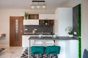a kitchen with white cabinets and green bar stools at Modern Central Studio in Sofia