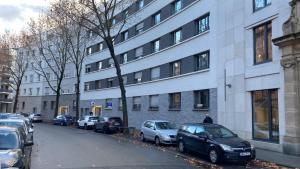 eine Straße mit Autos, die vor einem Gebäude geparkt sind in der Unterkunft Chic Studio : Super Zentral : 1min zum HBF in Mannheim
