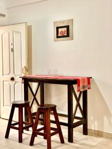 una mesa de madera con 2 taburetes en una habitación en Ayllu en Salta