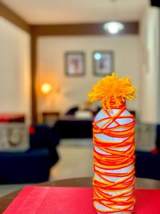 una botella de rayas roja y naranja sentada en una mesa en Ayllu en Salta