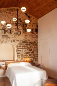 a bedroom with a bed with a stone wall at Casa Sanui. Apartaments turístics rurals in Estorm