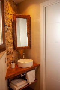 y baño con lavabo y espejo. en Casa Sanui. Apartaments turístics rurals, en Estorm