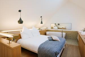 a bedroom with a large white bed and a mirror at B2 Hotel Zürich in Zurich