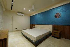 a bedroom with a bed and a blue wall at Woodlands Apartment- Fully furnished Luxury Apt in Jodhpur