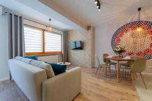 a living room with a couch and a table at Apartamenty Ogrodowa w centrum Ustronia - Dream Apart in Ustroń