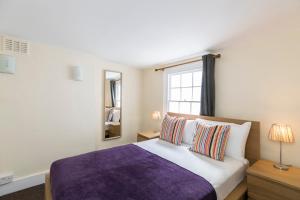 a bedroom with a purple bed and a window at Camden Town apartments in London