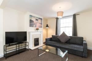a living room with a couch and a fireplace at Camden Town apartments in London