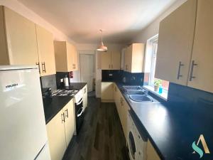 a kitchen with white cabinets and black counter tops at Aire Street -TSAC in Middlesbrough