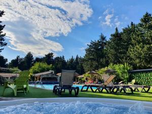 - une piscine avec 2 chaises longues, une table et des chaises dans l'établissement Les hebergements Insolites, à Taradeau