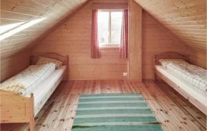 two beds in a log cabin with a window at Awesome Home In Auklandshamn With 4 Bedrooms 
