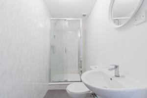 a white bathroom with a sink and a shower at Camden Town apartments in London