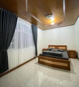 1 dormitorio con cama y ventana grande en Villa Nada Situgunung. 