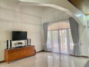 - un salon avec une télévision et une grande fenêtre dans l'établissement Villa Nada Situgunung., 