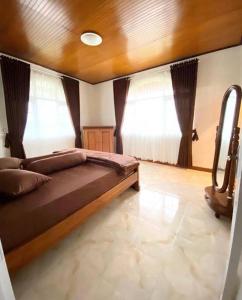 1 dormitorio con 1 cama grande y 2 ventanas en Villa Nada Situgunung. 